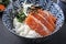 Traditional Japanese salmon sashimi with rice and vegetable on a design bowl