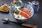 Traditional Japanese salmon sashimi with rice and vegetable on a design bowl