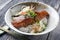 Traditional Japanese salmon teriyaki with rice and vegetable in a design bowl with chopstick on a wooden board