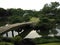 Traditional Japanese stroll garden with bridge across pond