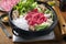 Traditional Japanese Sukiyaki with Kobe Beef in a cast-iron design Pot on a gas coocker