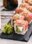 Traditional Japanese sushi with salmon, ginger and isabi on black stone texture board. Sushi serving in the restaurant