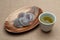 Traditional Japanese sweet called Daifuku Mochi on a wooden platter with green tea