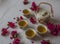 Traditional Japanese tea set filled with green tea and fresh red cheery blossom against white marble back