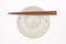 Traditional Japanese wooden chopstick on white ceramic plate
