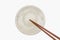 Traditional Japanese wooden chopstick on white ceramic plate