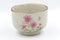 Traditional japonese tea cup with three pink flowers.