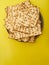 Traditional Jewish bread matzah on a sunny yellow background. High angle view. There is an empty space for an inscription.