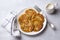 Traditional latkes fritters with sour cream on a light gray textured background