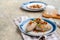 Traditional Lithuanian dish Zeppelin, boiled potato dumplings stuffed with minced pork, on a colored ceramic plate on a gray