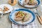 Traditional Lithuanian dish Zeppelin, boiled potato dumplings stuffed with minced pork, on a colored ceramic plate on a gray