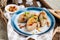 Traditional Lithuanian dish Zeppelin, boiled potato dumplings stuffed with minced pork, on a colored ceramic plate on a gray