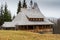 Traditional log house insulated with moss with shingle roof in the forest.