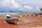 Traditional longtail boat on the sand beach at the low tide. Sea view with islands on horizon and clouds in the sky.