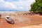 Traditional longtail boat on the sand beach at the low tide. Sea view with islands on horizon and clouds in the sky.