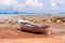 Traditional longtail boat on the sand beach at the low tide. Sea view with islands on horizon and clouds in the sky.