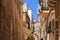 Traditional Maltese limestone buildings with coloured balconies in the vibrant alleys of the old city Birgu, Citta Vittoriosa