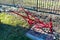 Traditional manual red plow made of steel, standing in the garden as an ornament.