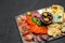Traditional meat and cheese plate - parmesan, meat, sausage and olives