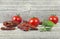 Traditional mediterranean kitchen - delicious dried tomatoes with fresh tomatoes, rosemary branch and basil leaf on wooden desk