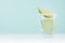 Traditional mexican alcohol drink - tequila in elegant shot glass with salt rim and green lime slice in modern pastel mint.