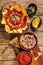 Traditional mexican refried beans with nachos, jalapeno and tomato sauce. Wooden background. Top view