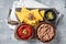 Traditional mexican refried beans with nachos, jalapeno and tomato sauce. Wooden background. Top view