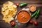 traditional mexican refried beans with nachos jalapeno and tomato sauce wooden background top view