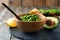 Traditional mexican sauce guacamole in bamboo bowl, lemon and cut half avocado on old wooden background.