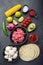 Traditional mexican tortilla with a mix of ingredients, corn, meat, vegetables, salsa, sauce over black textured background, top