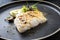 Traditional modern style Thai fried skrei cod fish filet with bok choi and mushrooms on a design plate