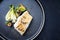 Traditional modern style Thai fried skrei cod fish filet with bok choi and mushrooms on a design plate