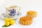 Traditional mooncake with teacup and small three oranges on leaves