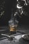 Traditional Moroccan teapot pouring tea into a steaming glass with natural tea and mint, on a dark background. Traditional