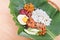 Traditional nasi lemak cuisine on banana leaf with fried chicken