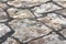 Traditional natural stone tiles sidewalk made from various size rocks held together with concrete fugue