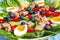 Traditional Nicoise Salad on a blue wooden background. Salad ingredients Tuna, Eggs, Potatoes, Green Beans, Cherry Tomatoes and