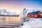 Traditional Norwegian red wooden houses rorbuer on the shore of  Reinefjorden near Hamnoy village at sunset