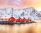 Traditional Norwegian red wooden houses rorbuer on the shore of  Reinefjorden near Hamnoy village at sunset