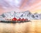 Traditional Norwegian red wooden houses rorbuer on the shore of  Reinefjorden near Hamnoy village at sunset