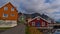 Traditional Norwegian wooden houses in village HenningsvÃ¦r, Lofoten, Norway with facades painted in red, orange and green colors.