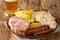 Traditional Oktoberfest recipe food sausage, Kassler pork neck, sauerkraut, mustard, boiled potatoes and light beer closeup.