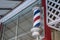 Traditional, old fashioned striped barber shop pole outside of the salon