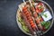 Traditional oriental adana kebap and shashlik skewer with tomato and flatbread on a rustic plate