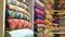 Traditional oriental multicolored fabrics stacked in store. Dubai market. Global village pavilion. Selective focus.  Small depth