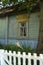 Traditional ornamented yellow open shutters of an old wooden rural house in the village of Belarus. Old shabby house