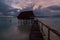 Traditional overwater thatched roof bungalow hut in lagoon of South Tarawa atoll, night, evening, twilight, sunset, Kiribati,