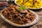 Traditional Persian lamb ragout xoresht-e badenjan with vegetable with steamed saffron rice and berberis on a classic design plate