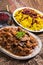 Traditional Persian lamb ragout xoresht-e badenjan with vegetable with steamed saffron rice and berberis on a classic design plate