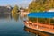 Traditional pletna boat on the waters of Lake Bled with Bled Castle cliff on the background, Upper Carniola, Slovenia. Colorful